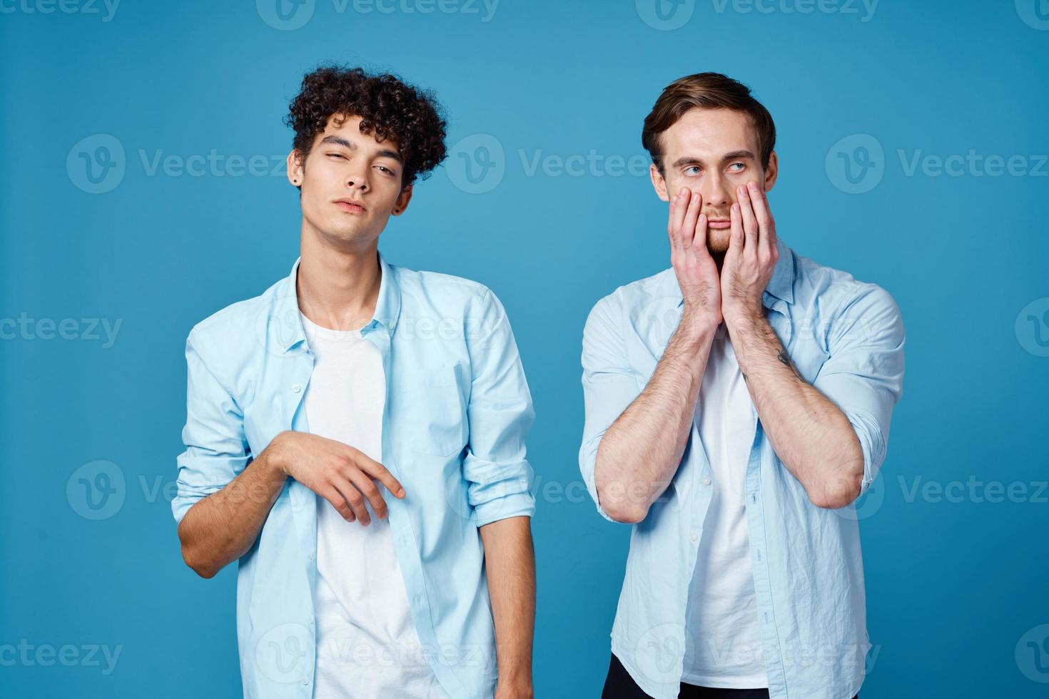 Happy friends in identical shirts chatting on a blue background fun model photo