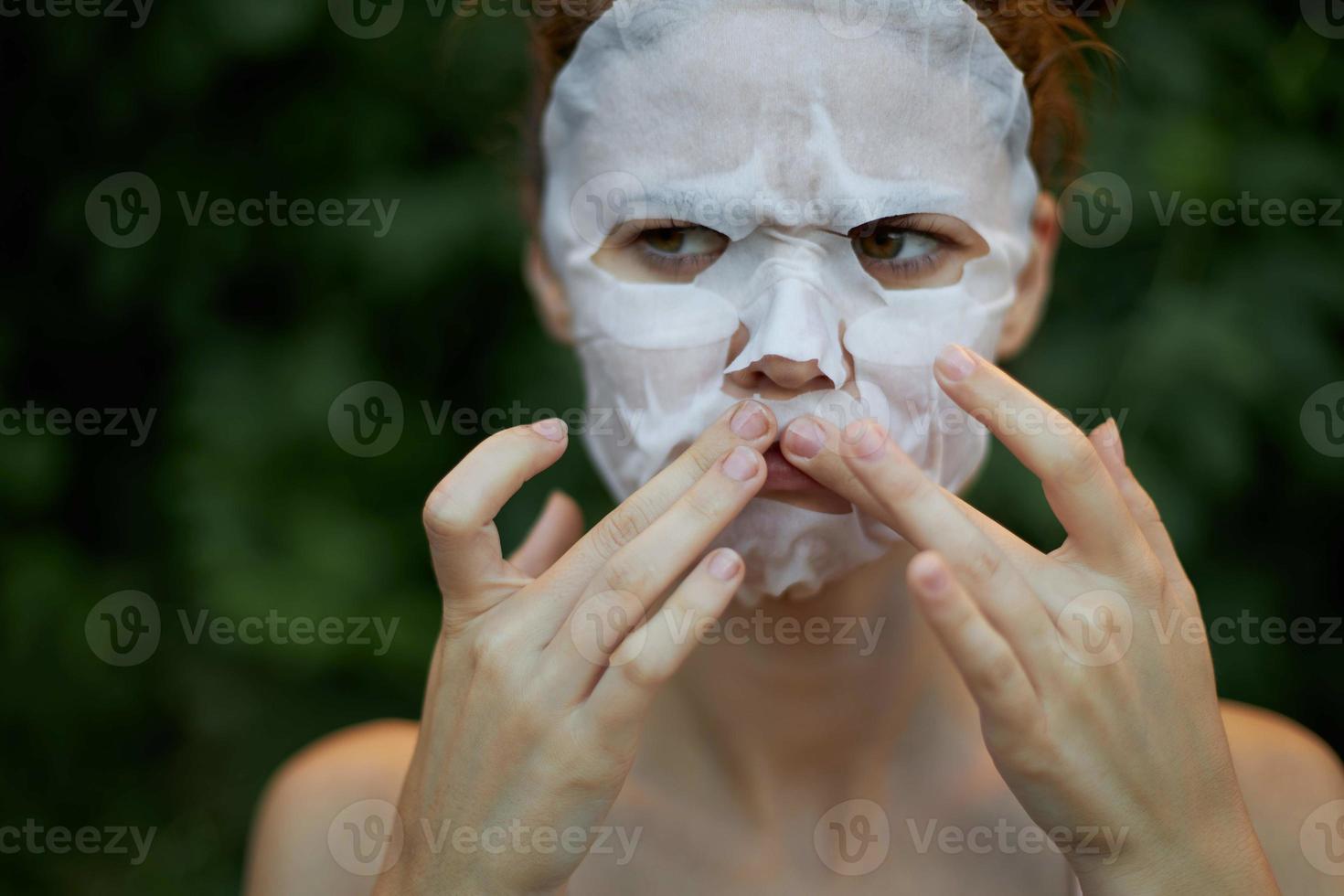 bonito mujer anti arrugas máscara prensa tu dedos cerca el labios dermatología verde arbustos antecedentes foto