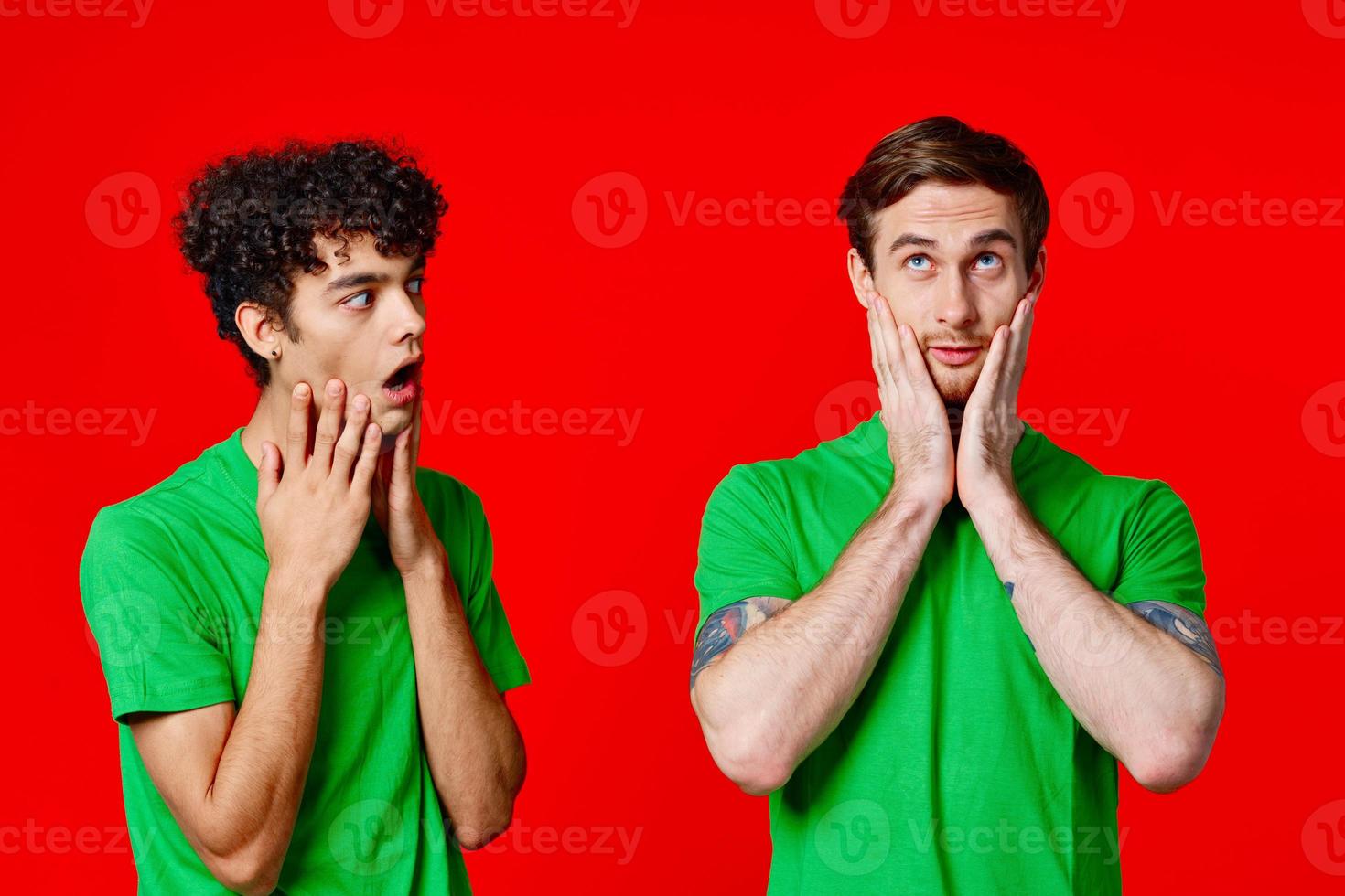 Cheerful friends in green t-shirts hold on to the face of emotion photo
