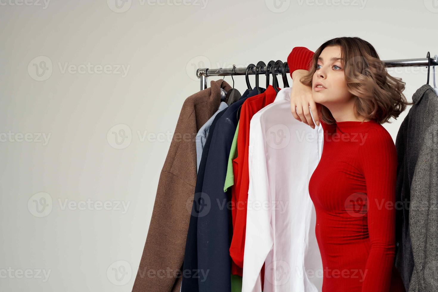 cheerful woman trying on clothes shop shopaholic light background photo