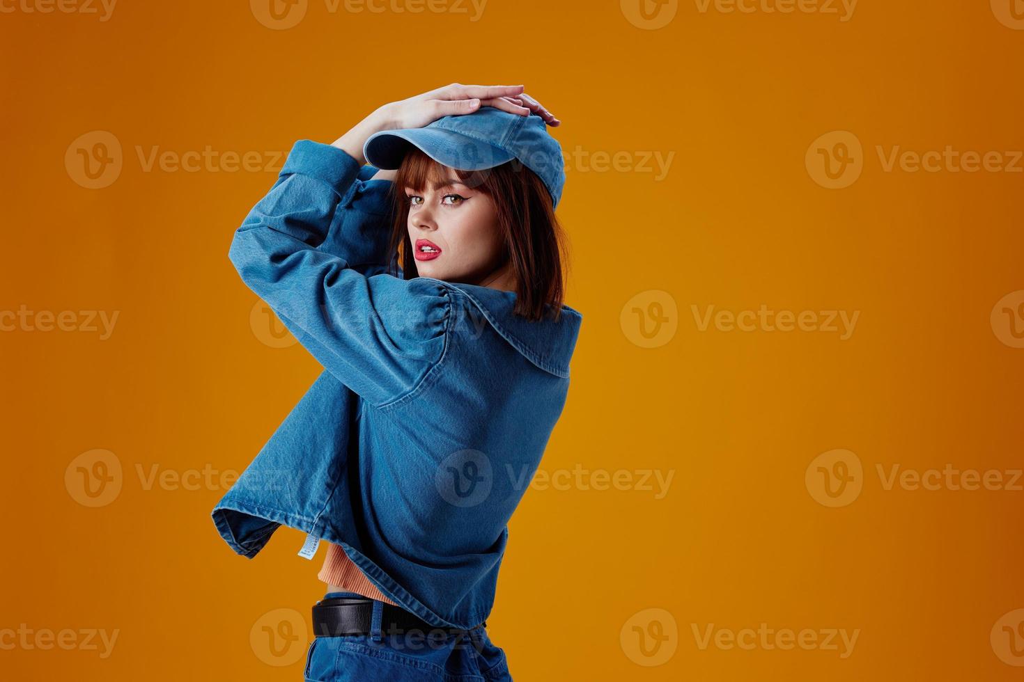Portrait of a charming lady stylish denim clothing posing yellow background unaltered photo
