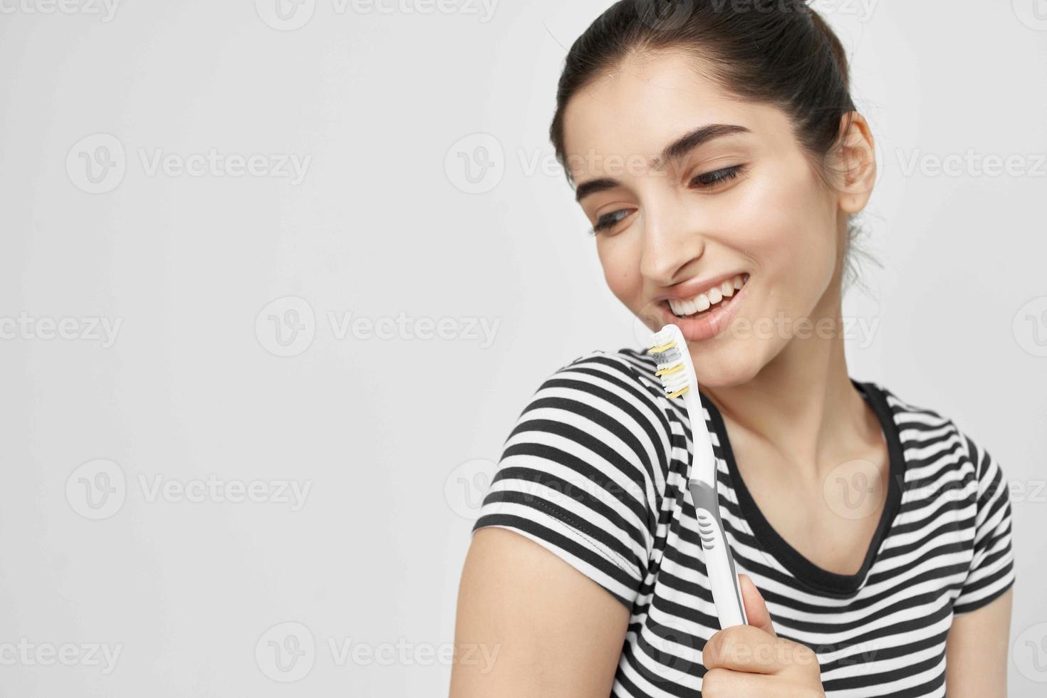 alegre mujer cepillo tu dientes con un cepillo de dientes ligero antecedentes foto