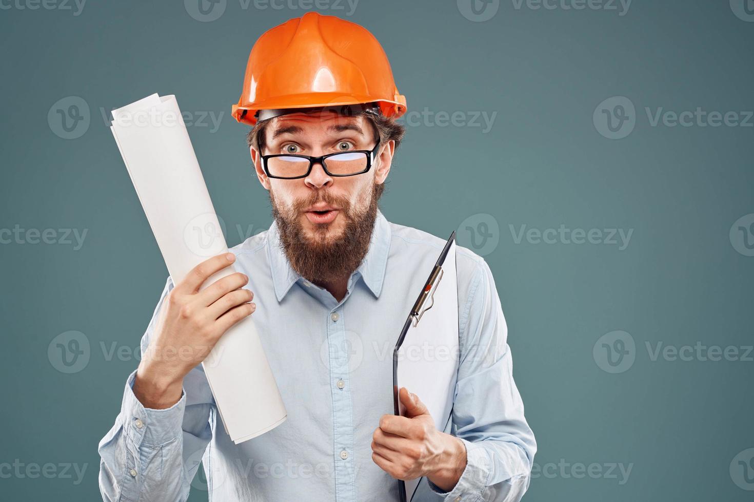 emocional hombre vistiendo lentes naranja casco la seguridad planos en manos profesional trabajo foto