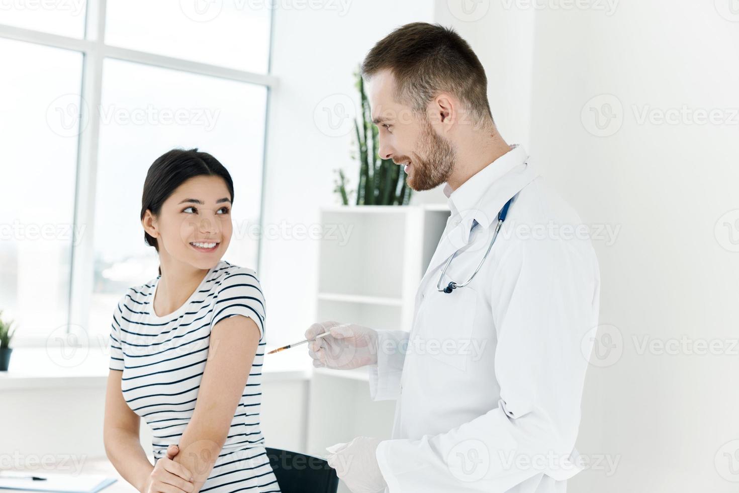 male doctor next to the patient giving an injection in the shoulder vaccination photo