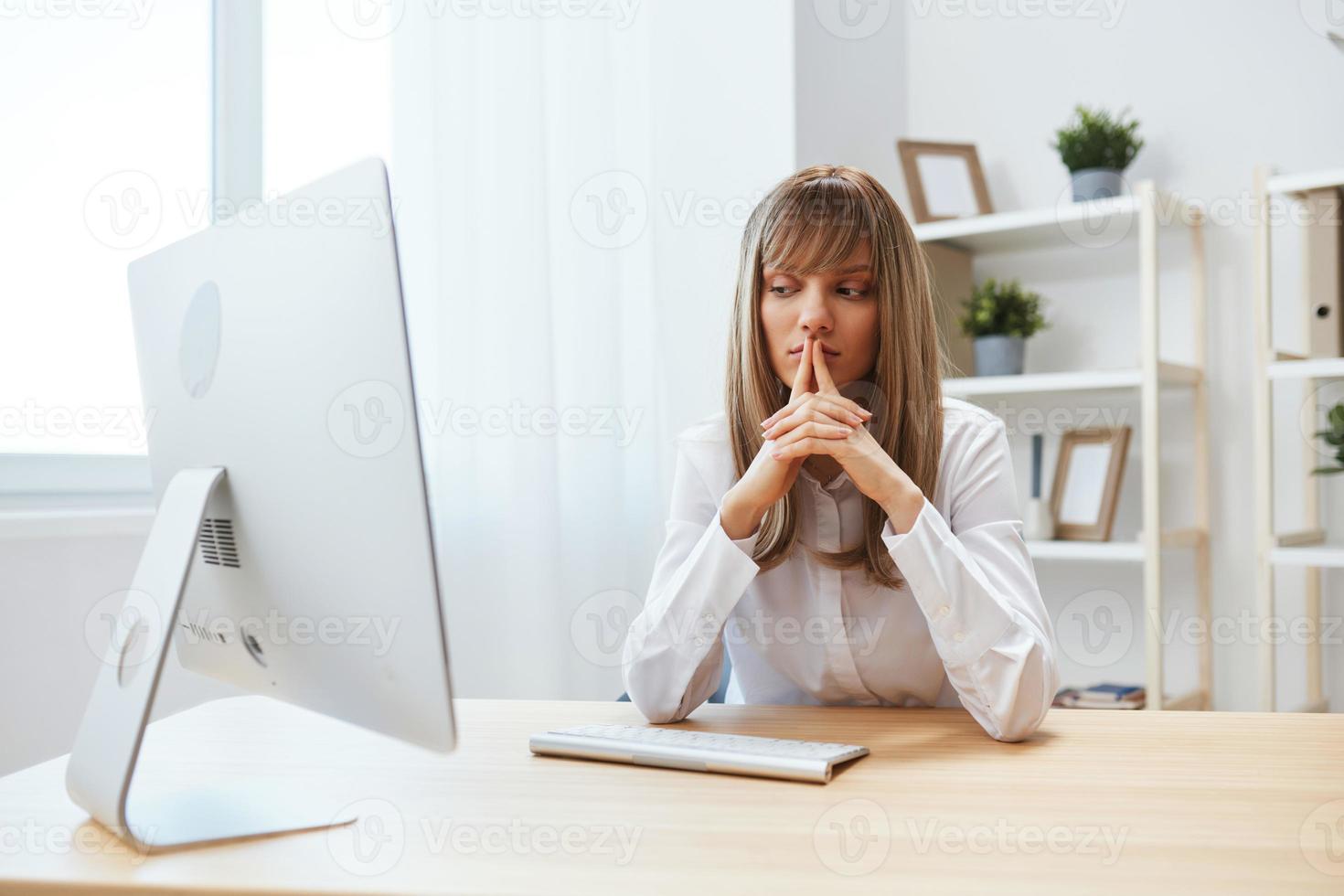 Pensive adorable blonde businesswoman look aside thinking of problem solution folded hands in light modern office. Thoughtful employee work on computer online pondering or making decision. Copy space photo