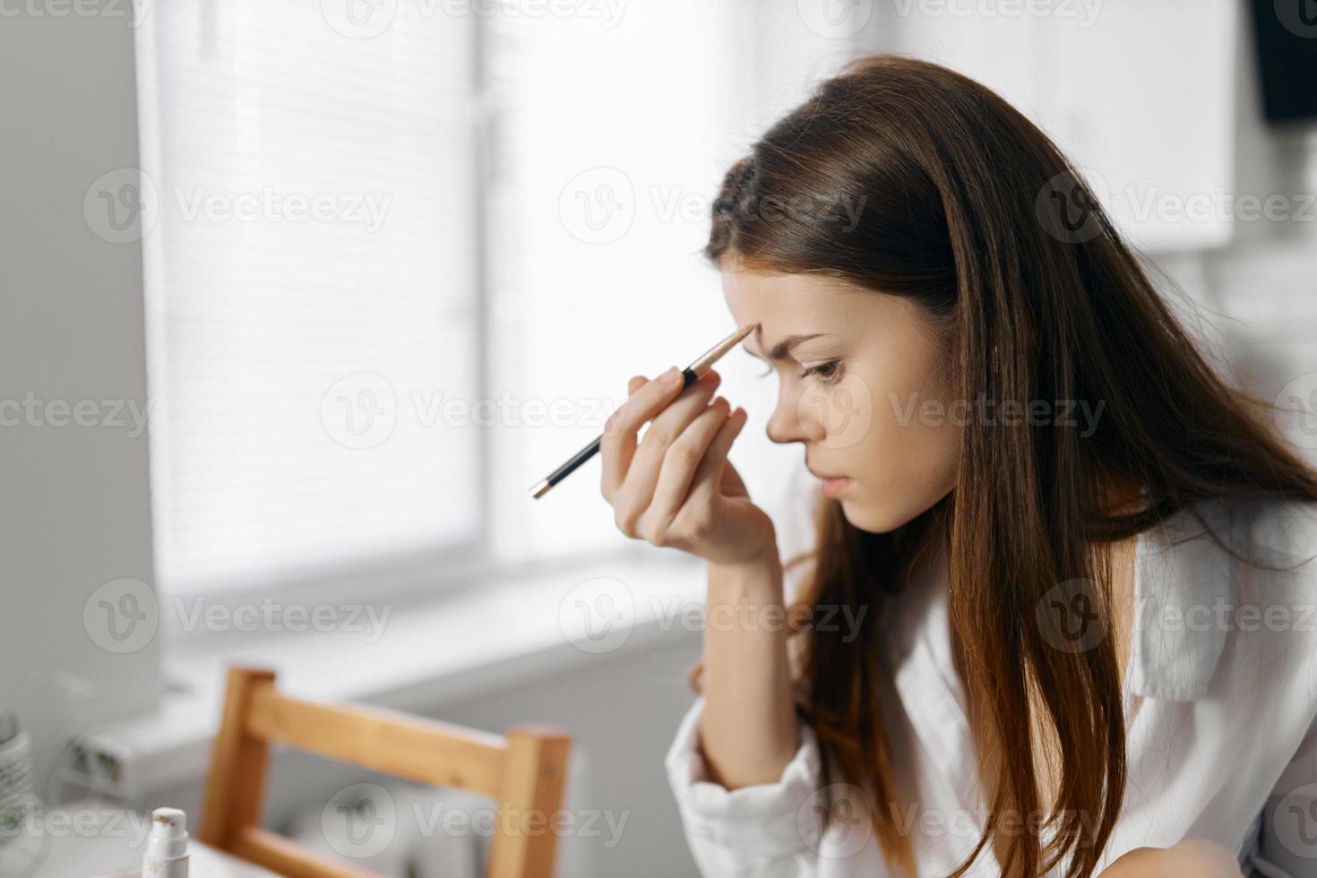 mujer con lápiz delineador de ojos Fundación maquillaje a hogar foto