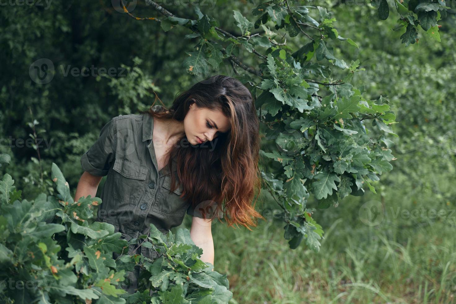 Woman outdoors Nature looks down green leaves summer photo