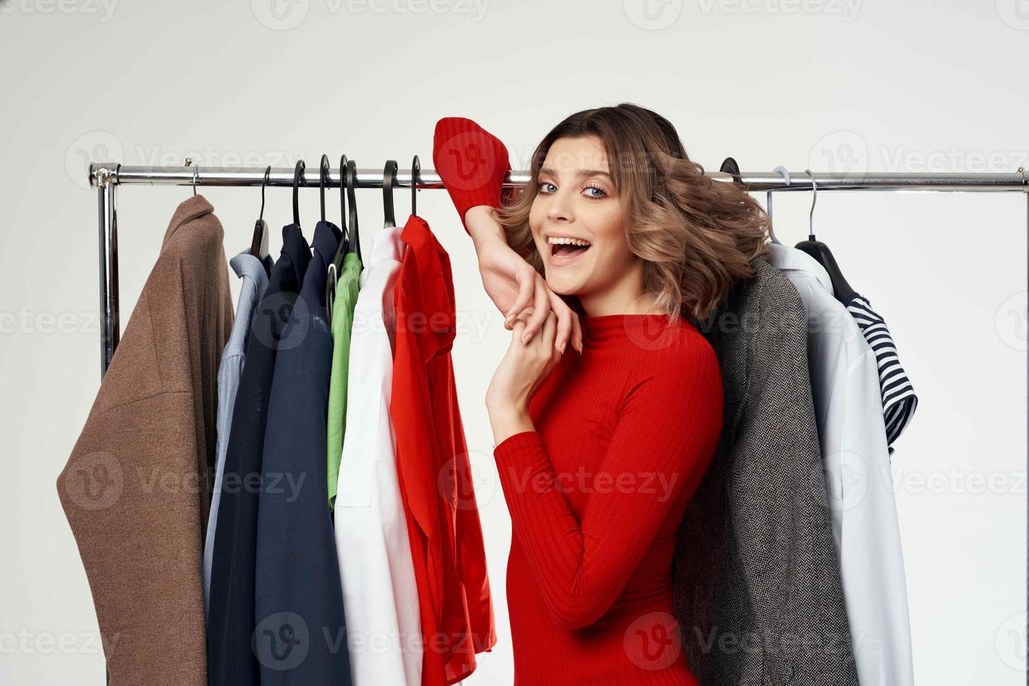 cheerful woman next to clothes fashion fun retail isolated background photo