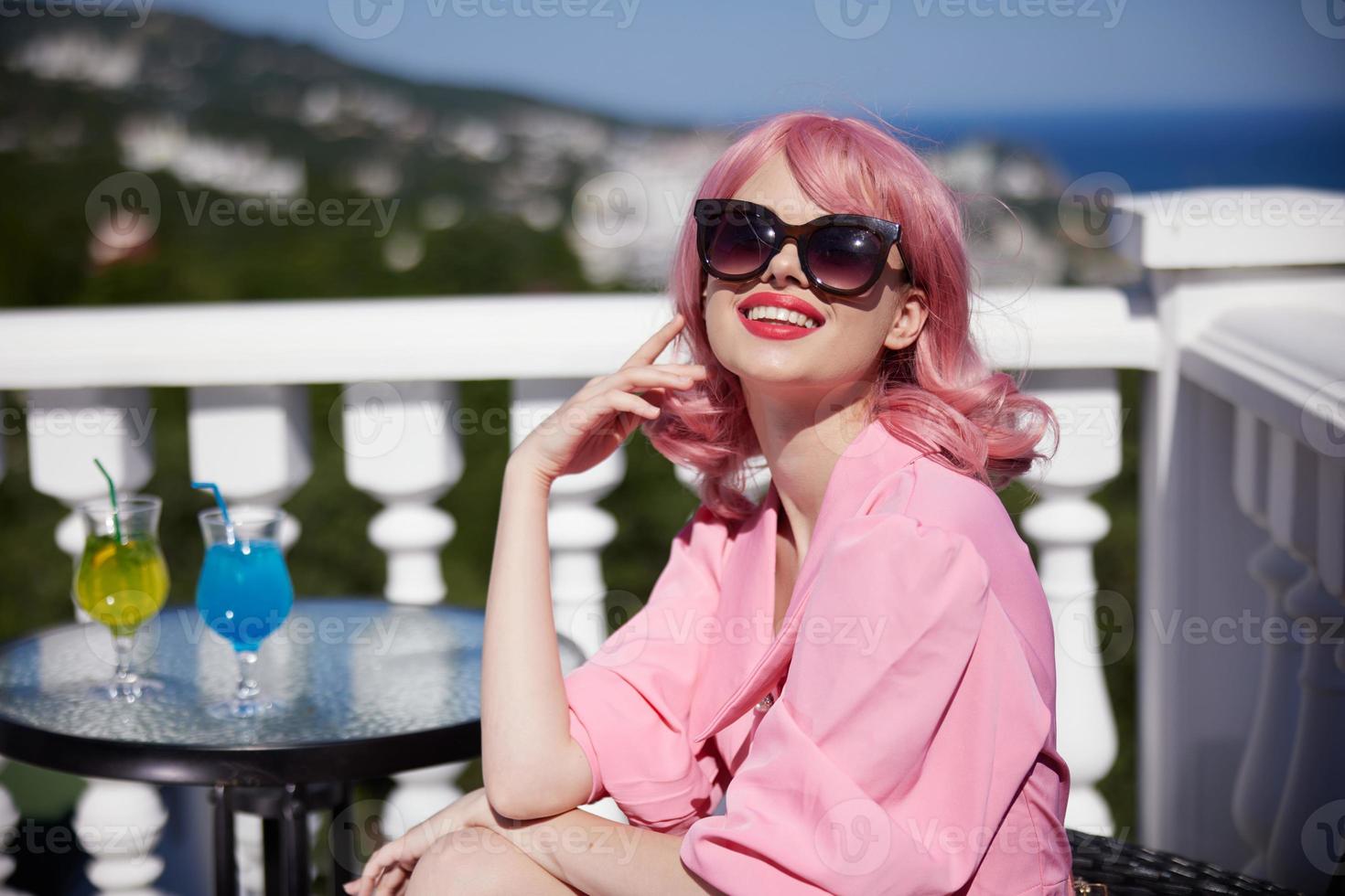 glamorous woman sit at the table in dark glasses with a cocktail sunny day photo