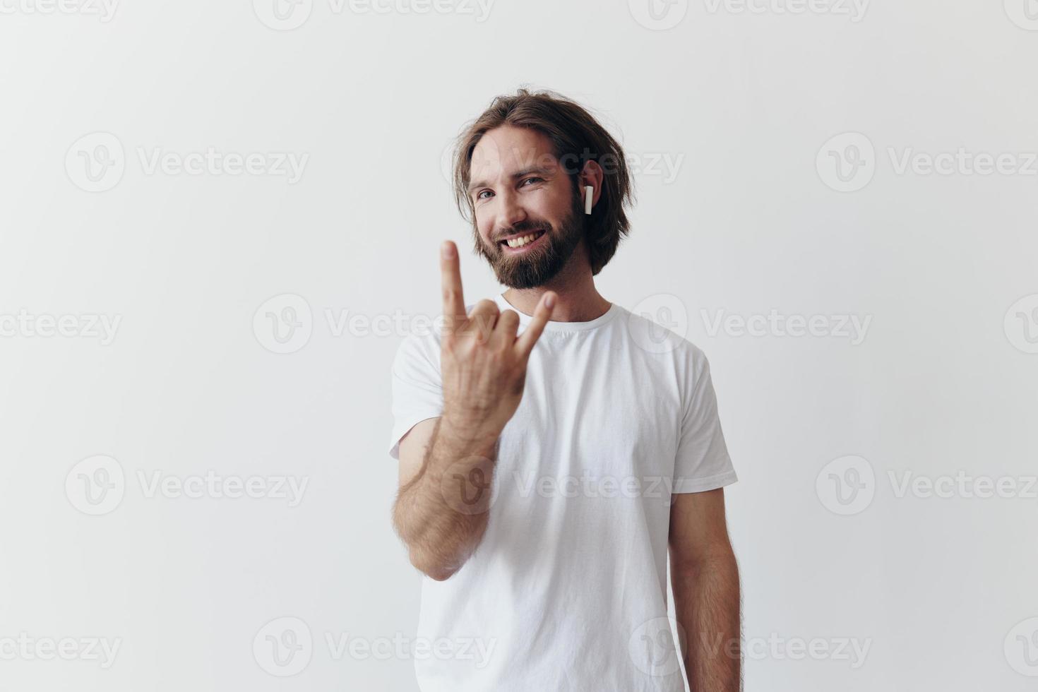 Stylish man in a white t-shirt with wireless headphones in his ears having fun listening to music smile on a white background lifestyle photo