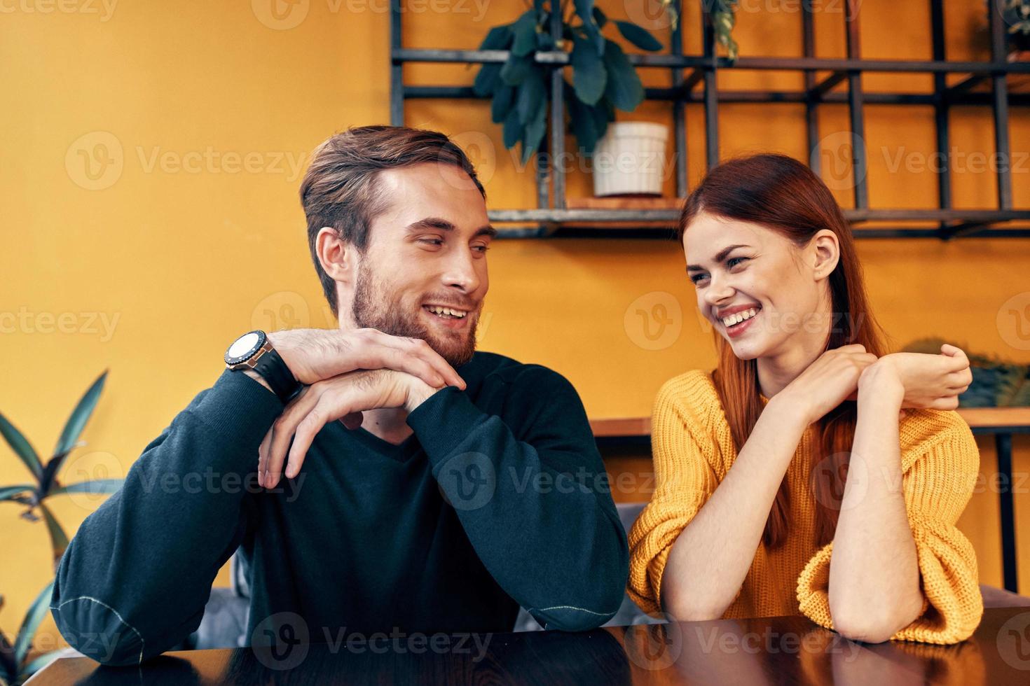 young couple sitting in a restaurant chatting dating photo