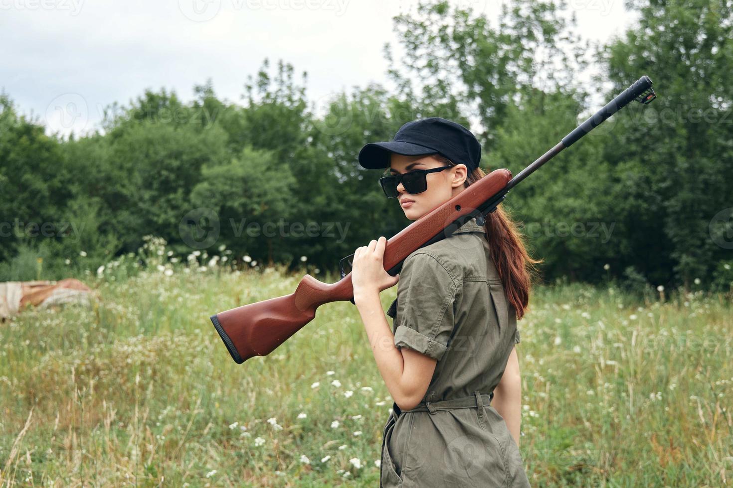 mujer soldado vistiendo Gafas de sol caza viaje armas armas verde foto