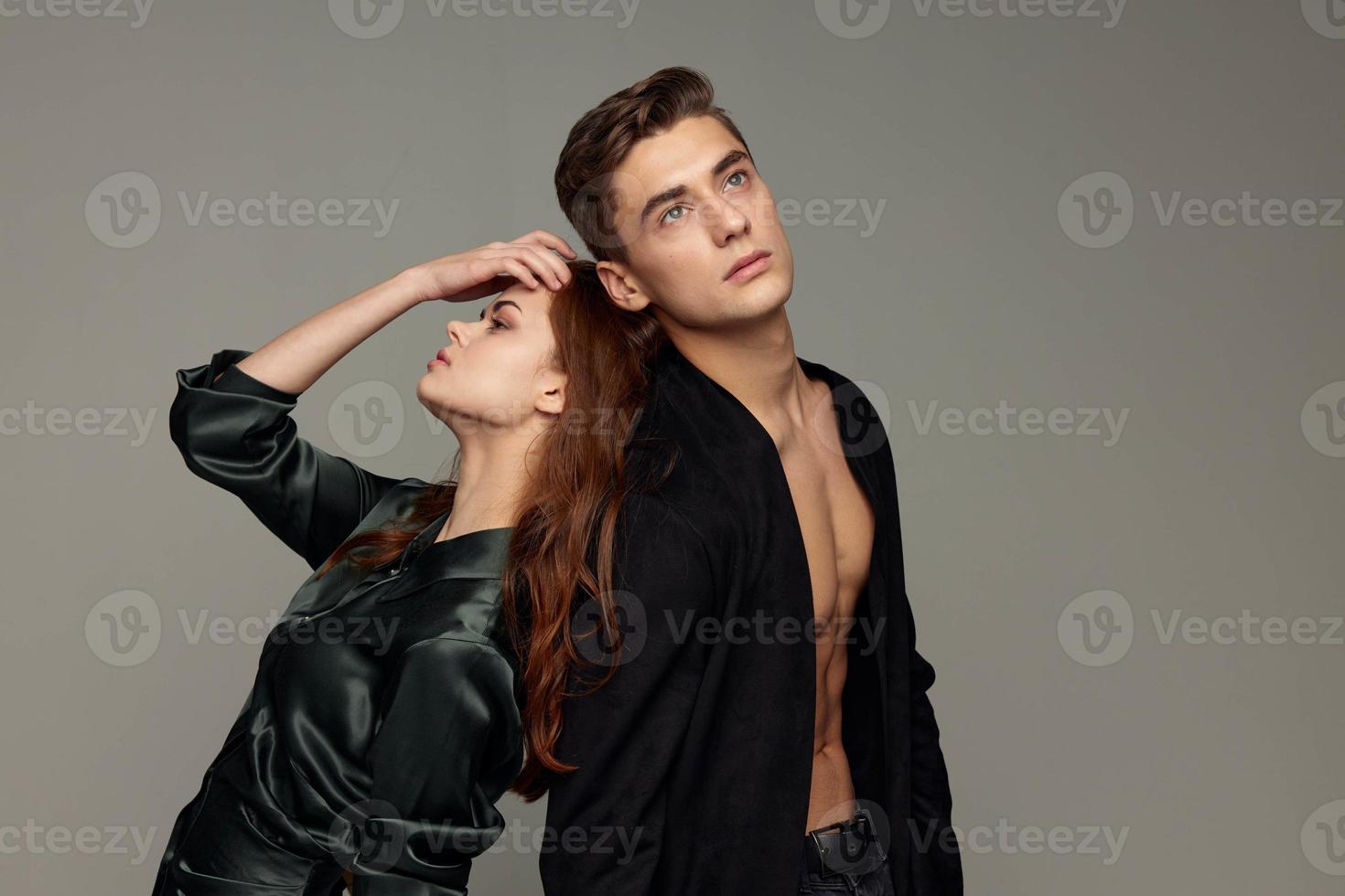 A woman touches her head with her hand and a sexy man with a naked torso photo