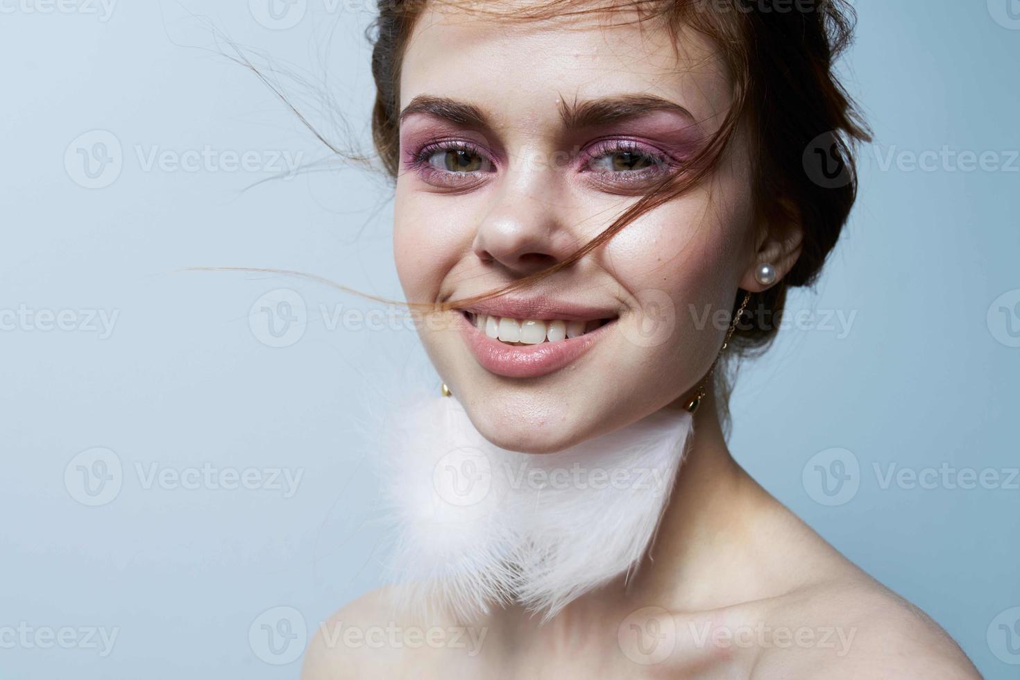 cheerful woman with bare shoulders fluffy earrings bright makeup photo