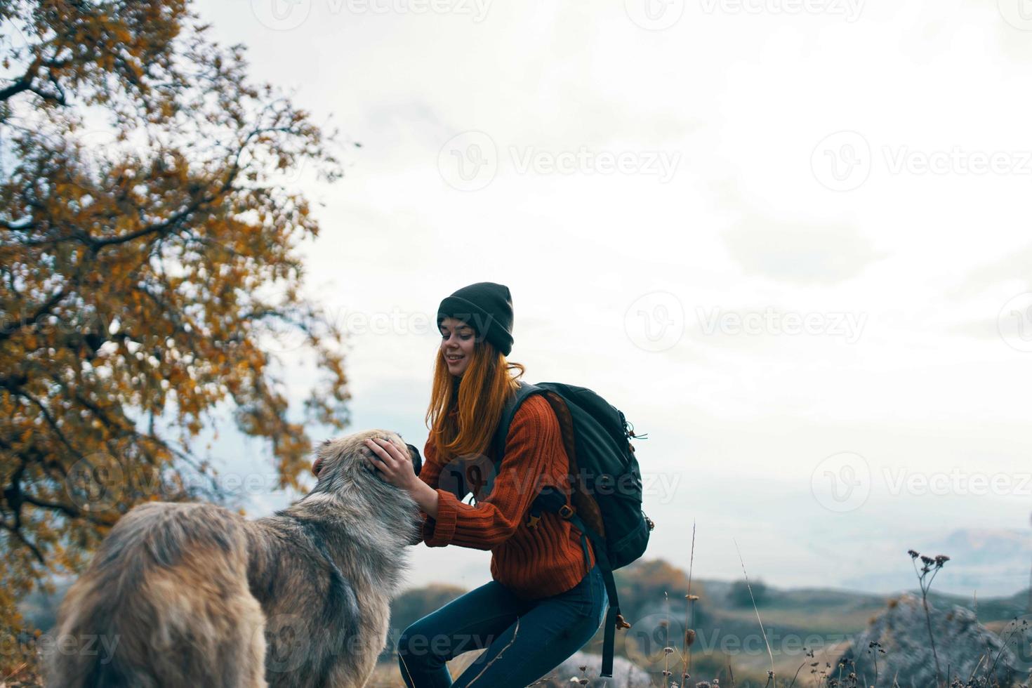 woman hiker with a backpack in nature with a dog photo