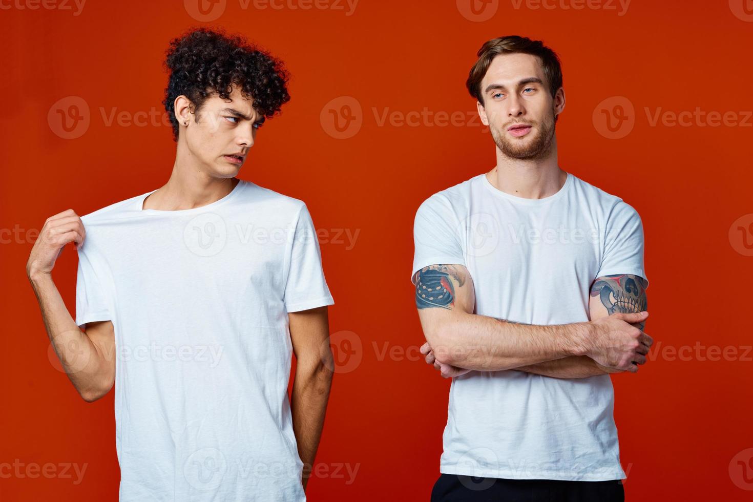 two men in white t-shirts on a red background friendship photo