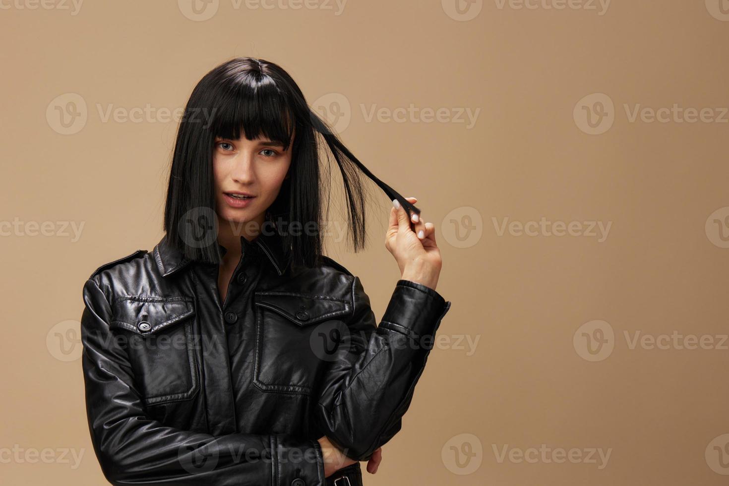 Self confident pretty adorable brunet lady in leather jacket flirting at camera posing isolated on pastel beige studio background. Copy space Banner Offer. Pulp Fiction concept. Fashion Cinema photo