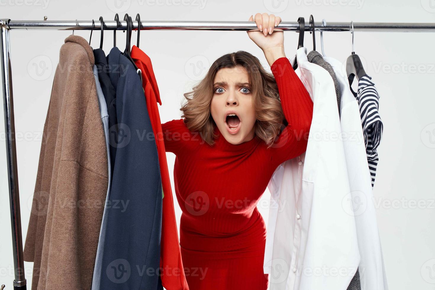 beautiful woman with glasses next to clothes fashion fun light background photo