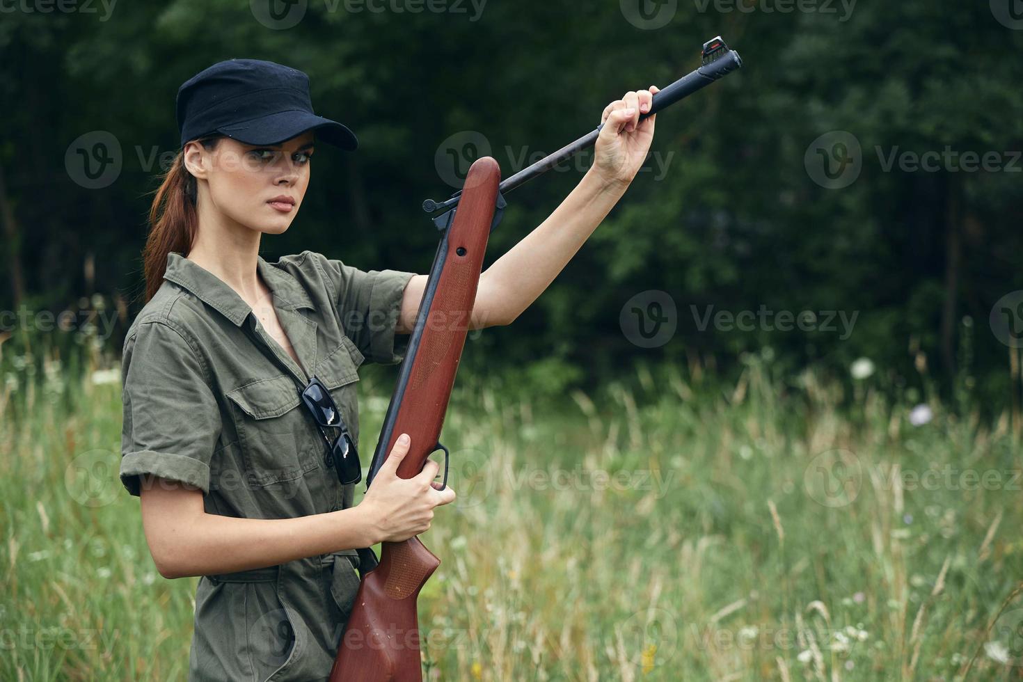 mujer soldado en verde mono recarga pistolas naturaleza Fresco aire armas foto