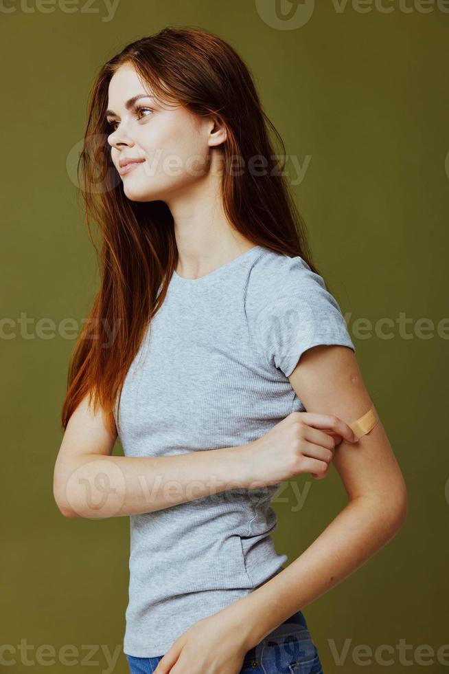 pretty woman with adhesive plaster on her arm covid-19 passport vaccination photo