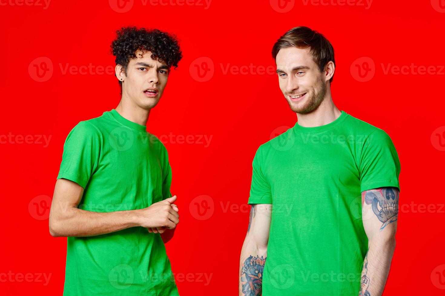 Cheerful friends in green t-shirts hold on to the face of emotion photo