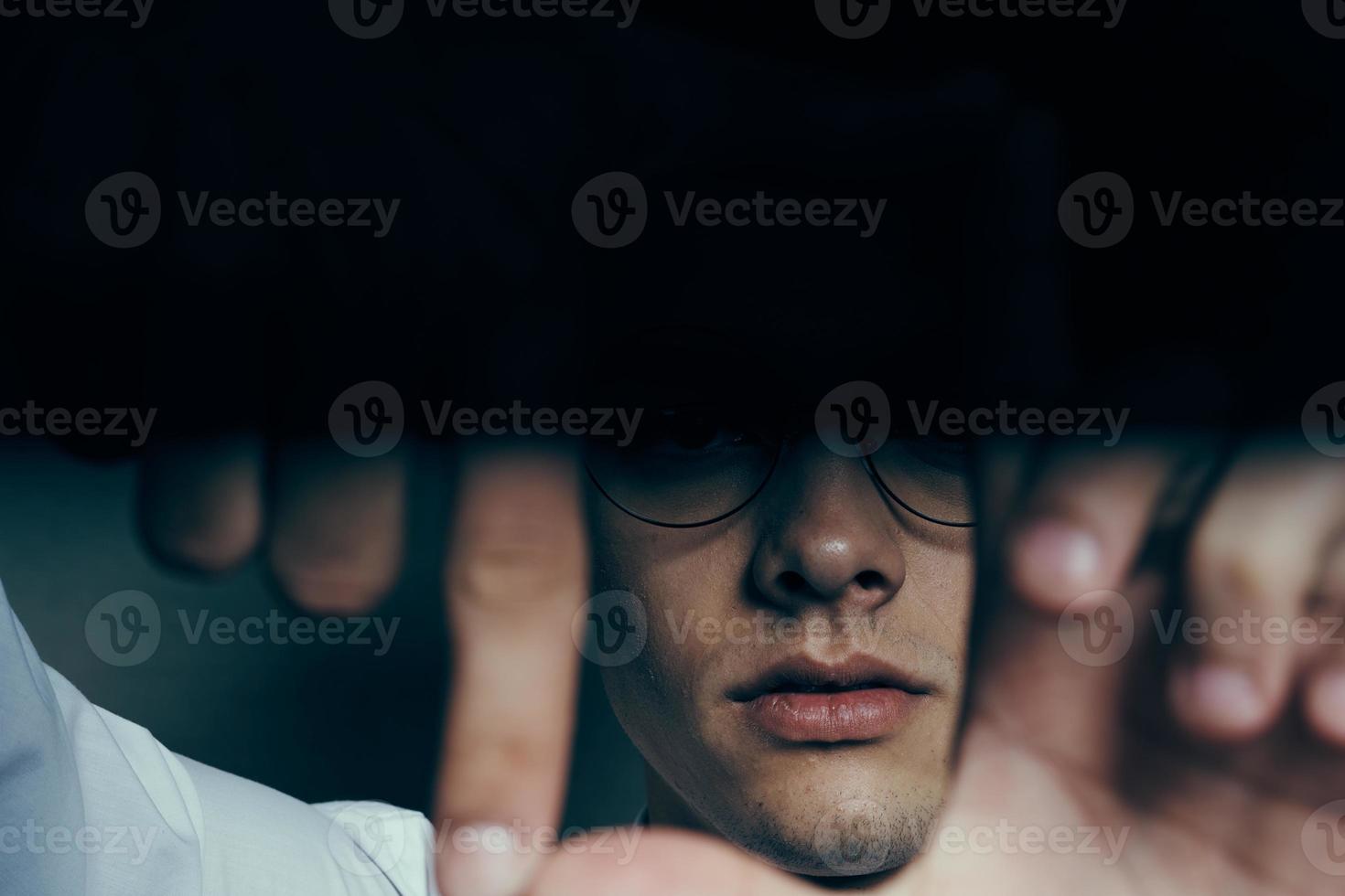 fashionable guy with curly hair gesturing with his hands on a gray background portrait close-up photo
