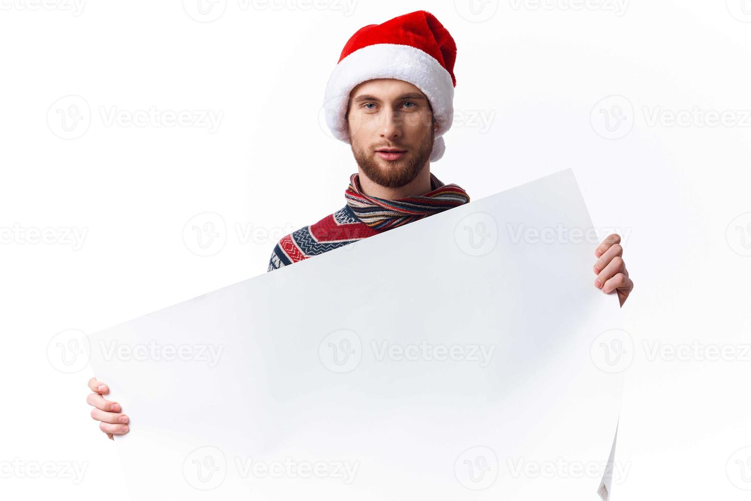 handsome man in a christmas hat with white mockup poster christmas light background photo