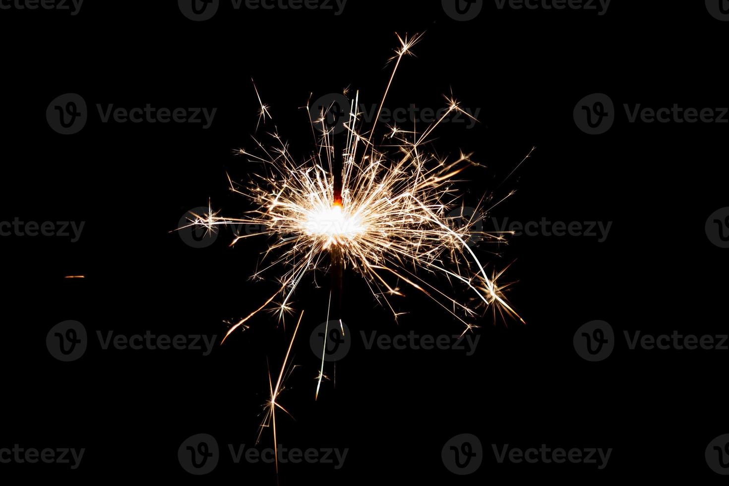 Burning sparkler isolated on black background. Fireworks theme. Light effect and texture. photo