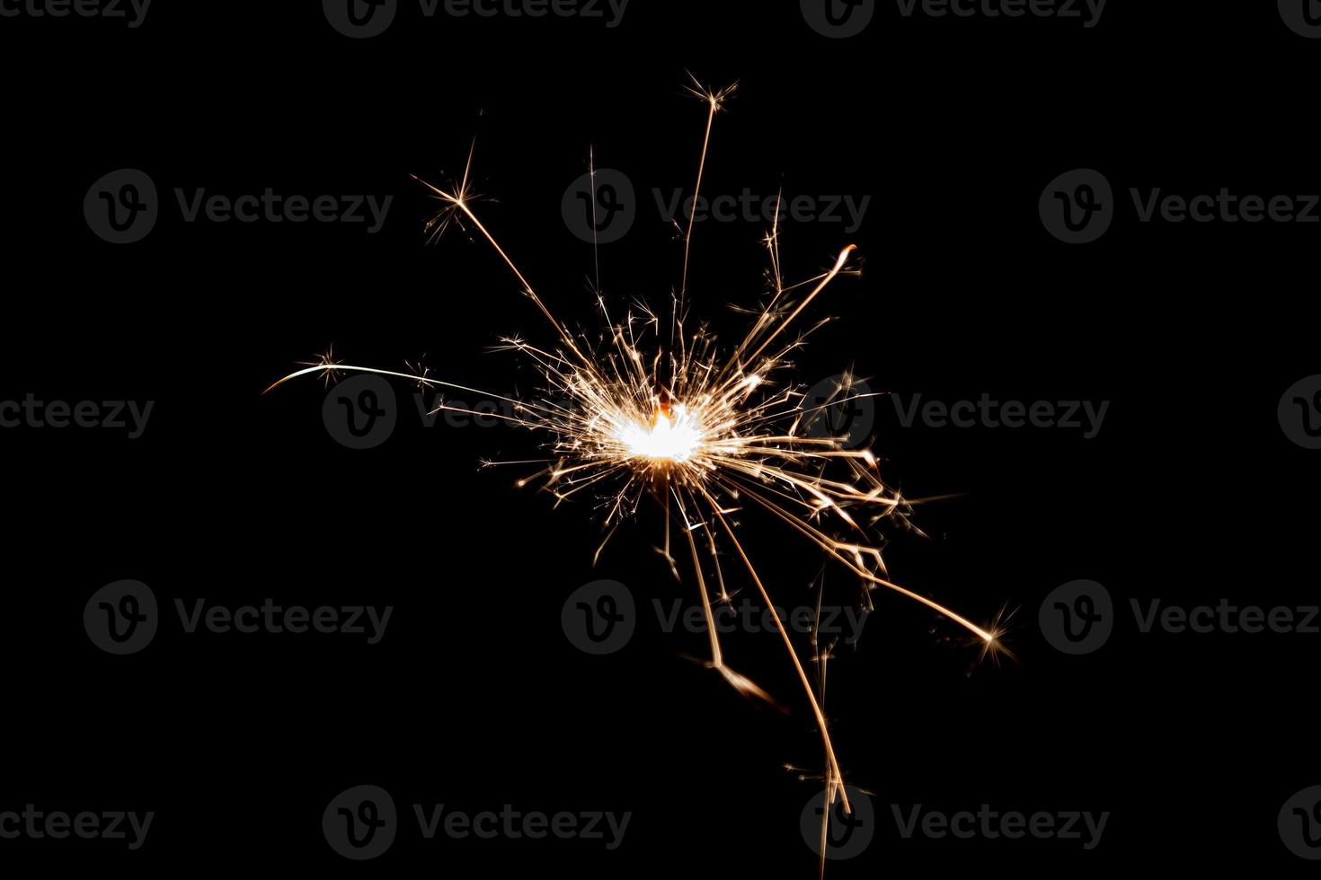 Burning sparkler isolated on black background. Fireworks theme. Light effect and texture. photo
