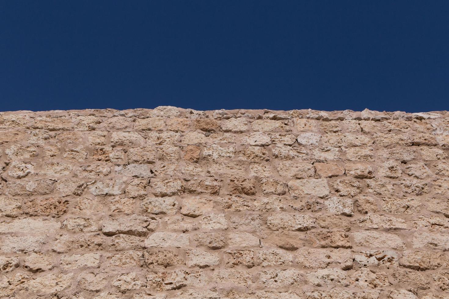 wall made of coquina stones against blue sky photo