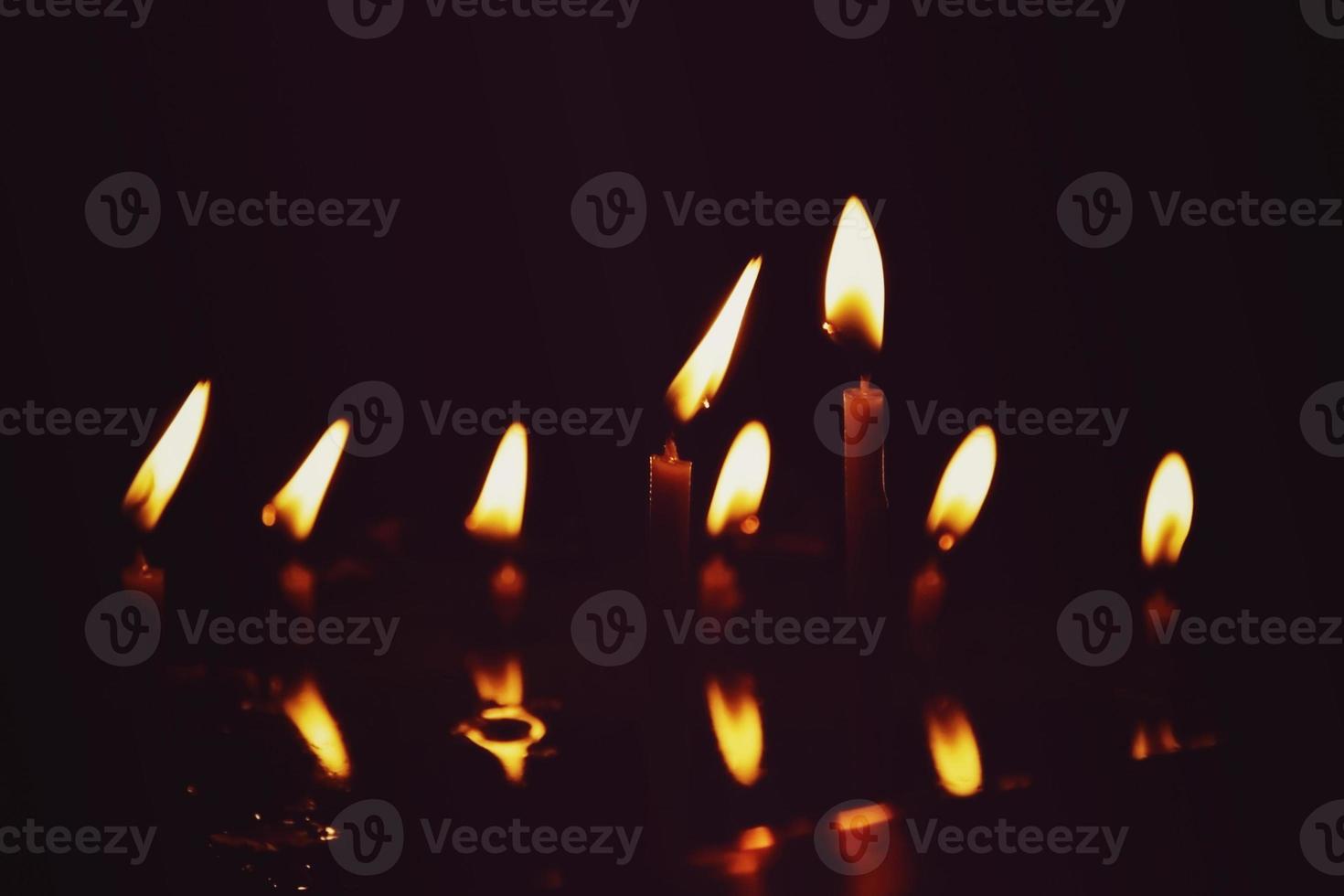 Prayer candles burning in the dark church photo