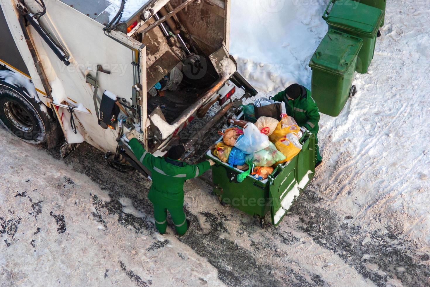 garbage collection workers pick up household waste in winter photo