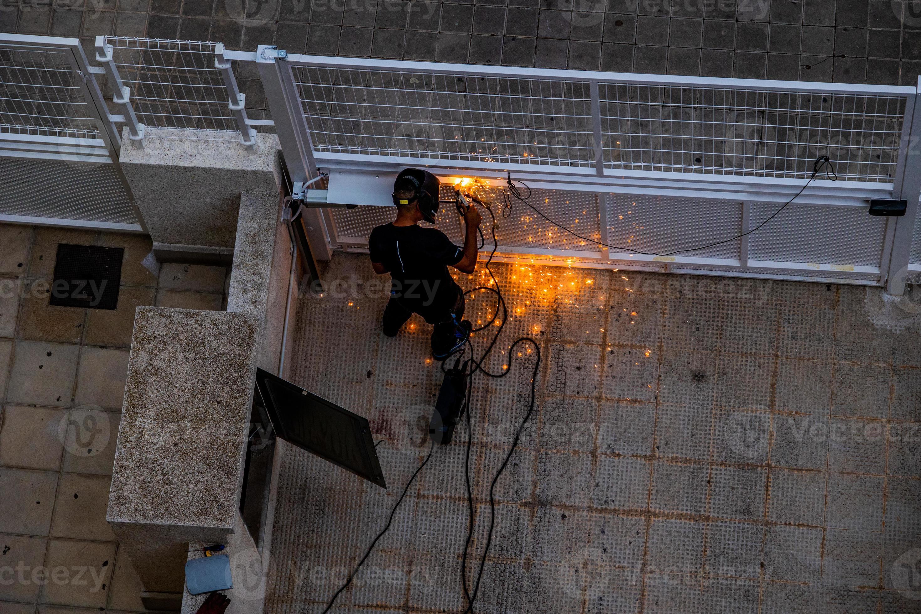 welder at work at a metal gate top view 22259726 Stock Photo at Vecteezy