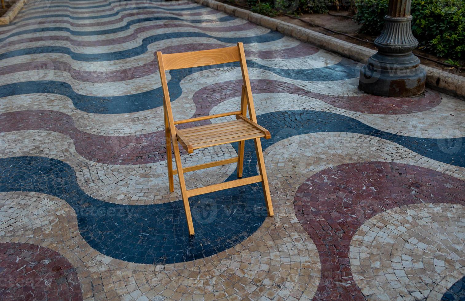 Explanada promenade in Alicante Spain landmark with wooden empty chair on mosaic photo