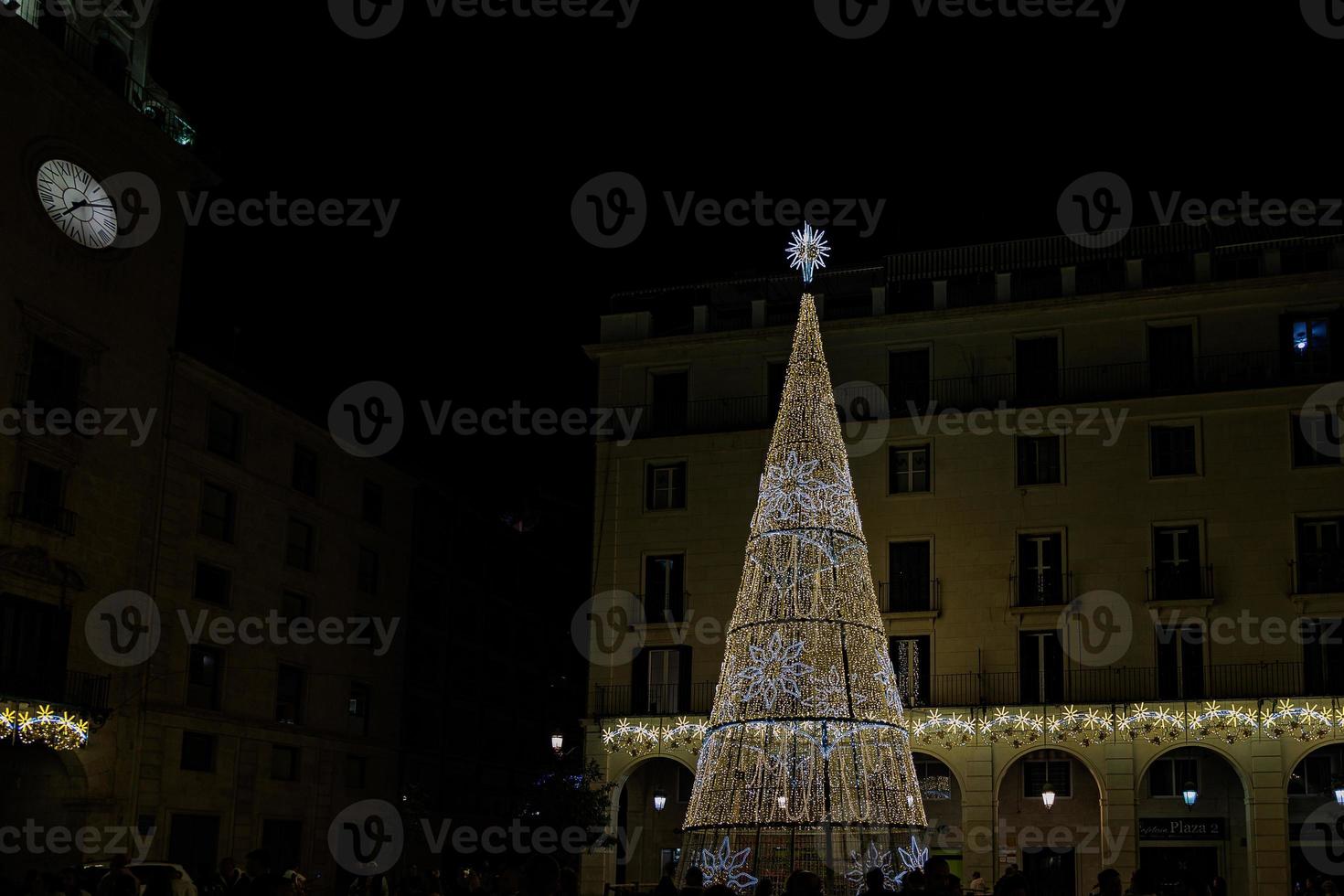 golden glowing christmas tree decoration on black background Alicante Spain in front of the town hall photo