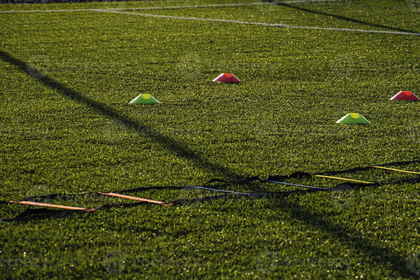 training football pitch with artificial green grass and training aids illuminated by the afternoon  sun photo