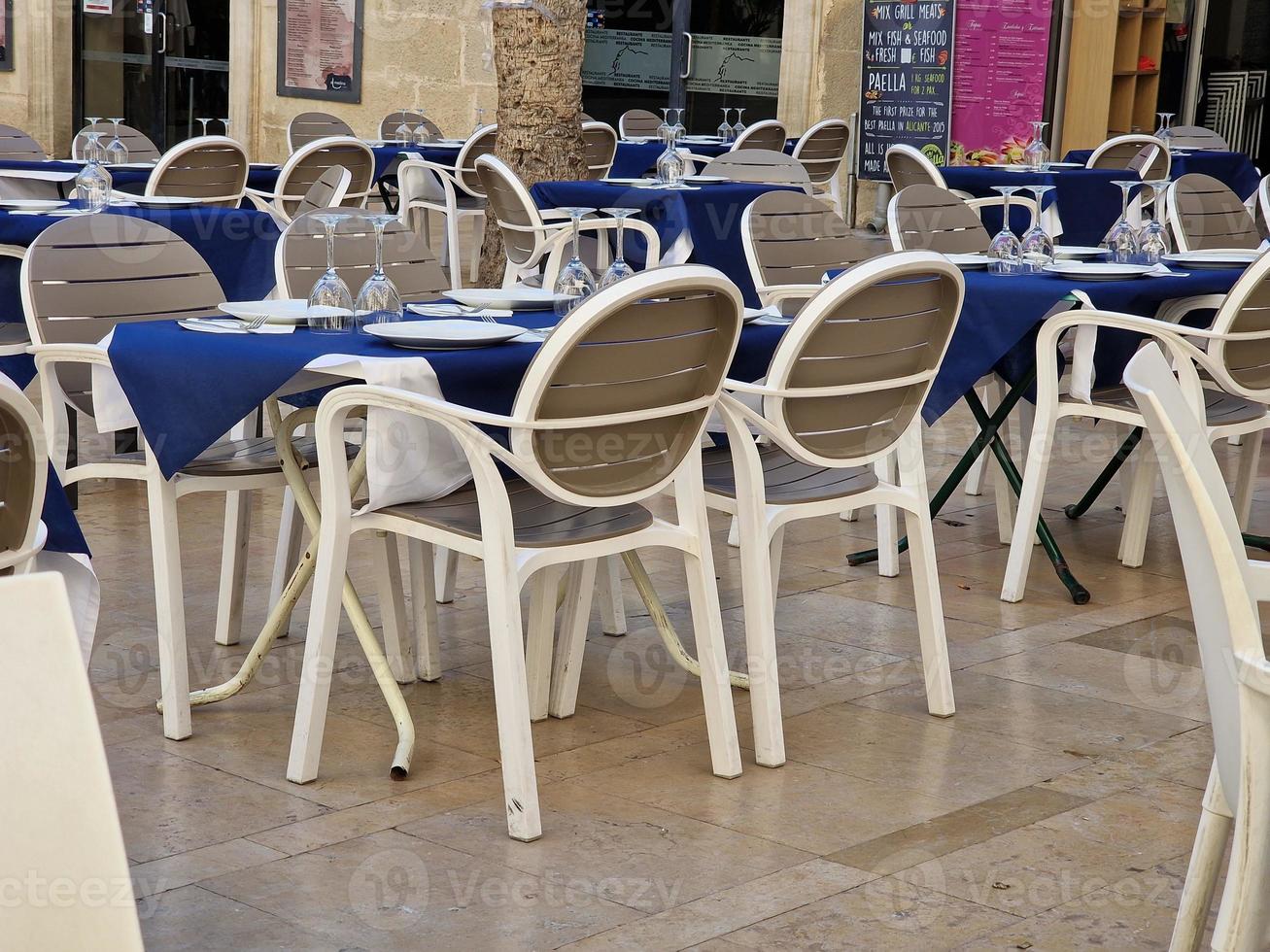 white tables with navy blue tablecloth in restaurant waiting for customers in spain photo