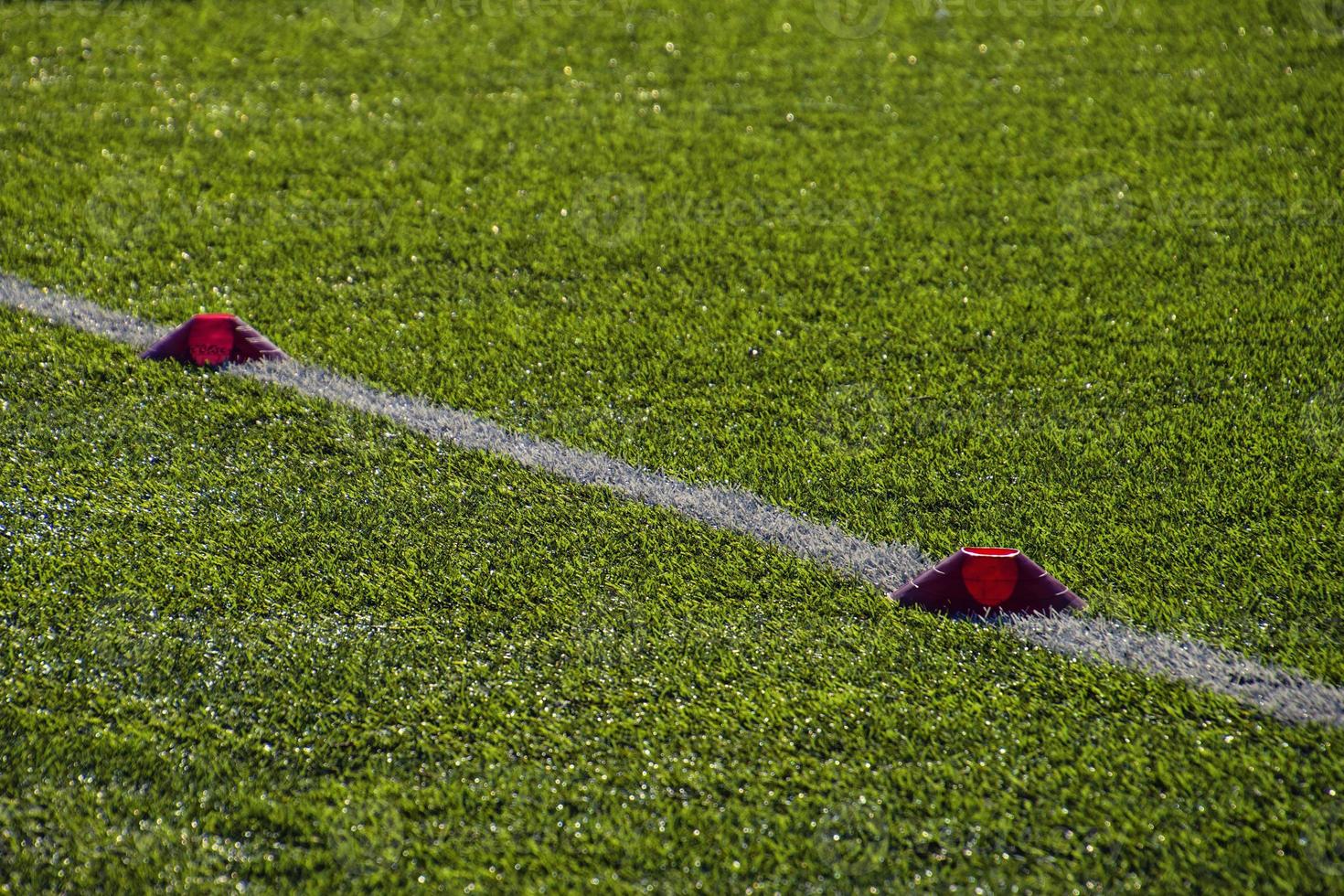 training football pitch with artificial green grass and training aids illuminated by the afternoon  sun photo