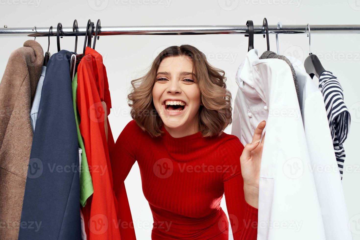 beautiful woman in a red jacket near the wardrobe light background photo
