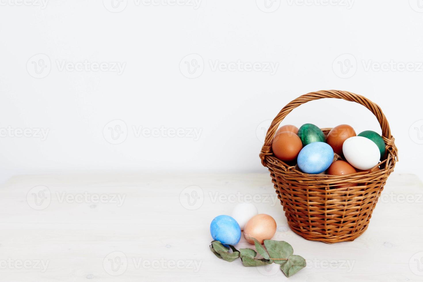 painted Easter eggs in a basket on a Light background Copy Space photo