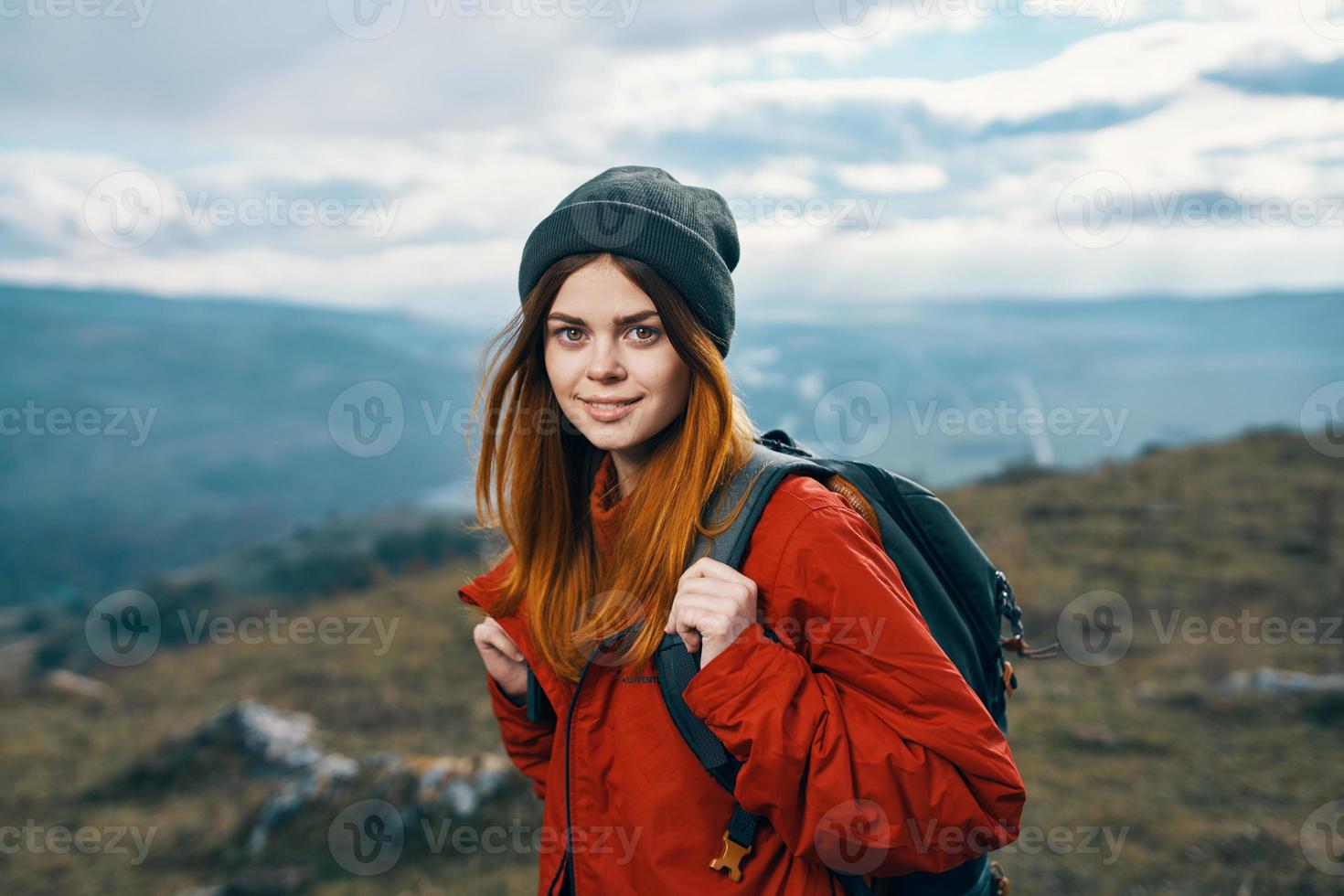 young traveler with backpack and mountains in the background landscape sky clouds photo