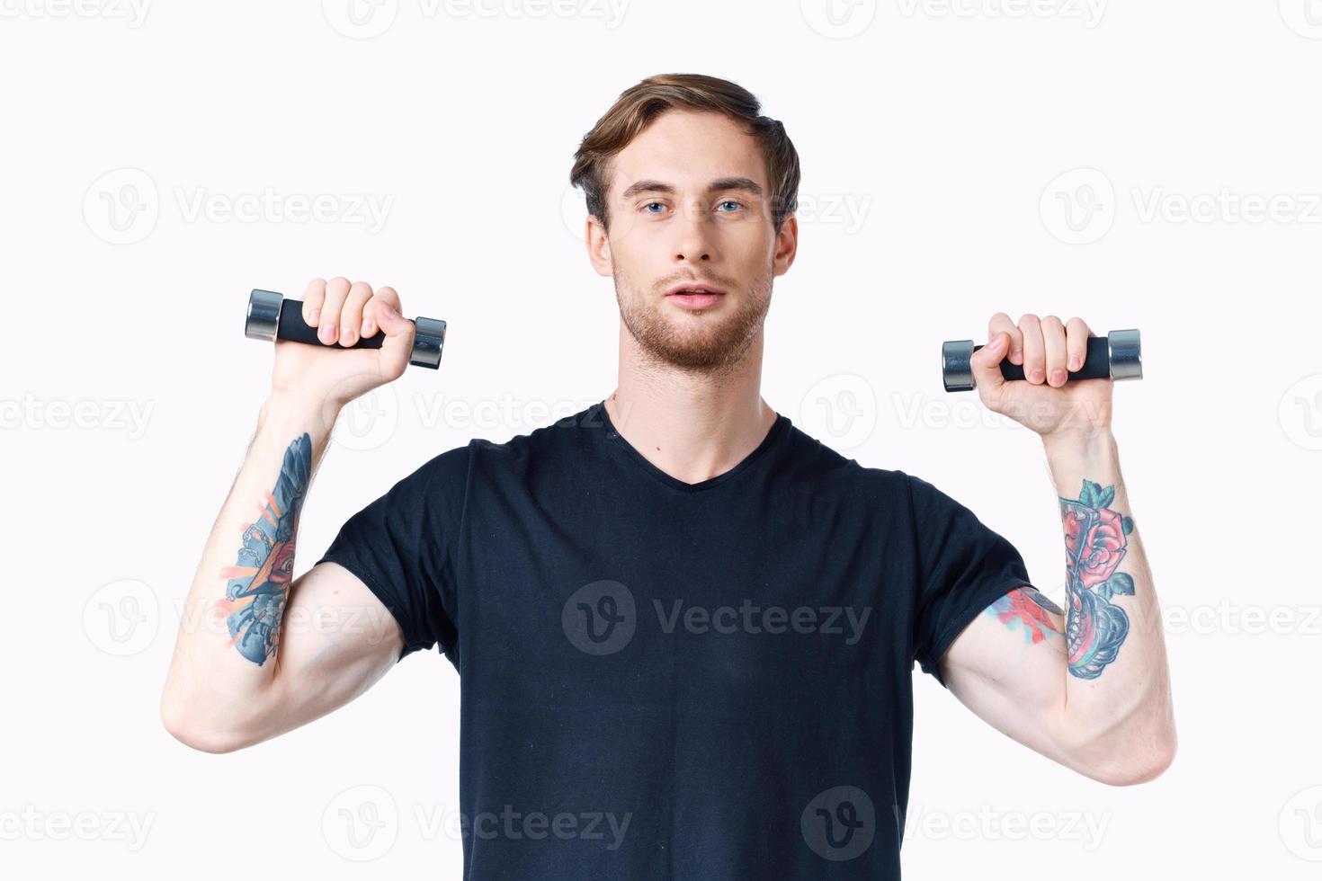 athlete with dumbbells in his hands and in a black t-shirt exercise fitness bodybuilder photo