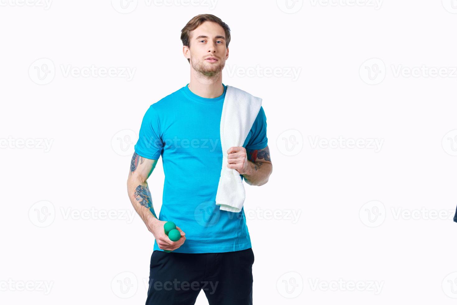 sporty man with dumbbells in hand, towel on shoulder doing exercises photo