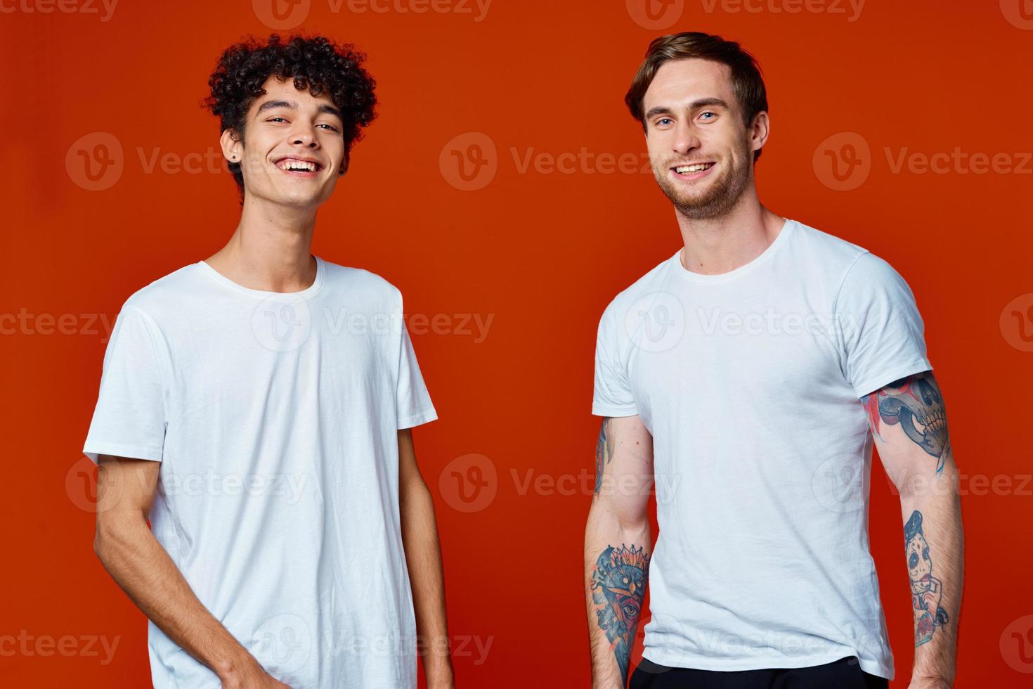 two men in white t-shirts on a red background friendship photo