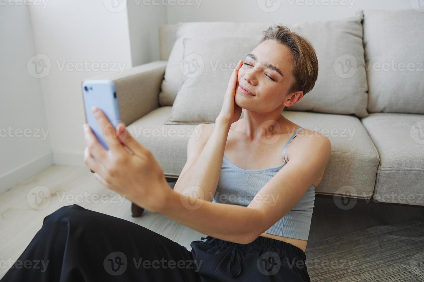 Woman blogger selfies on phone, selfies and online conversations for followers, teenager develops social media, freelancer from home photo