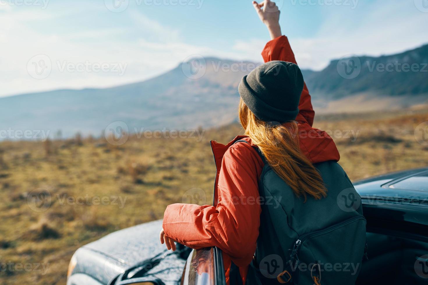 woman near cars gesturing with her hands on nature in the mountains autumn backpack travel tourism photo