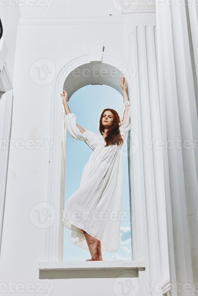 un mujer en un Boda vestir en un en forma de arco ventana apertura foto