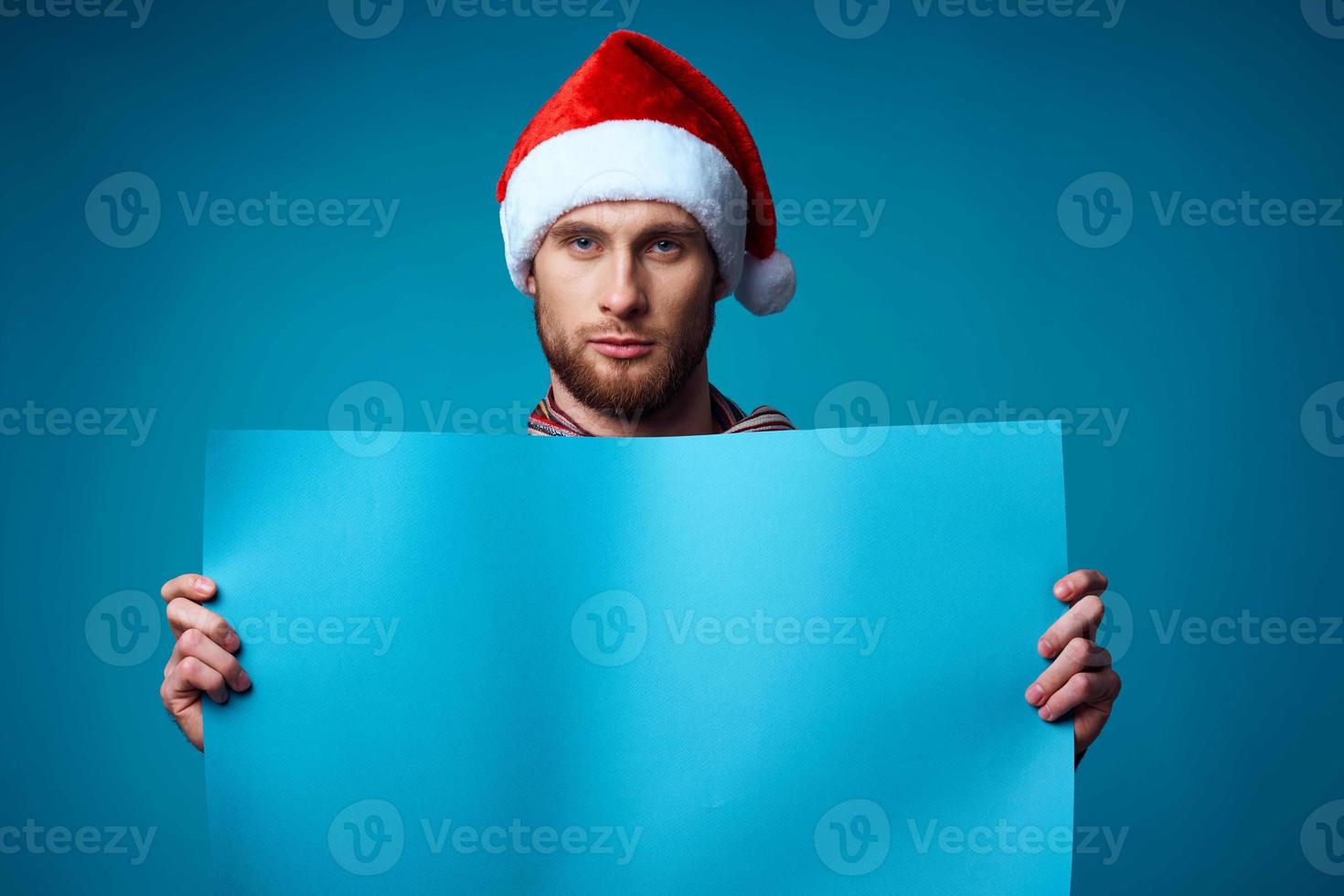 Cheerful man in a santa hat holding a banner holiday isolated background photo