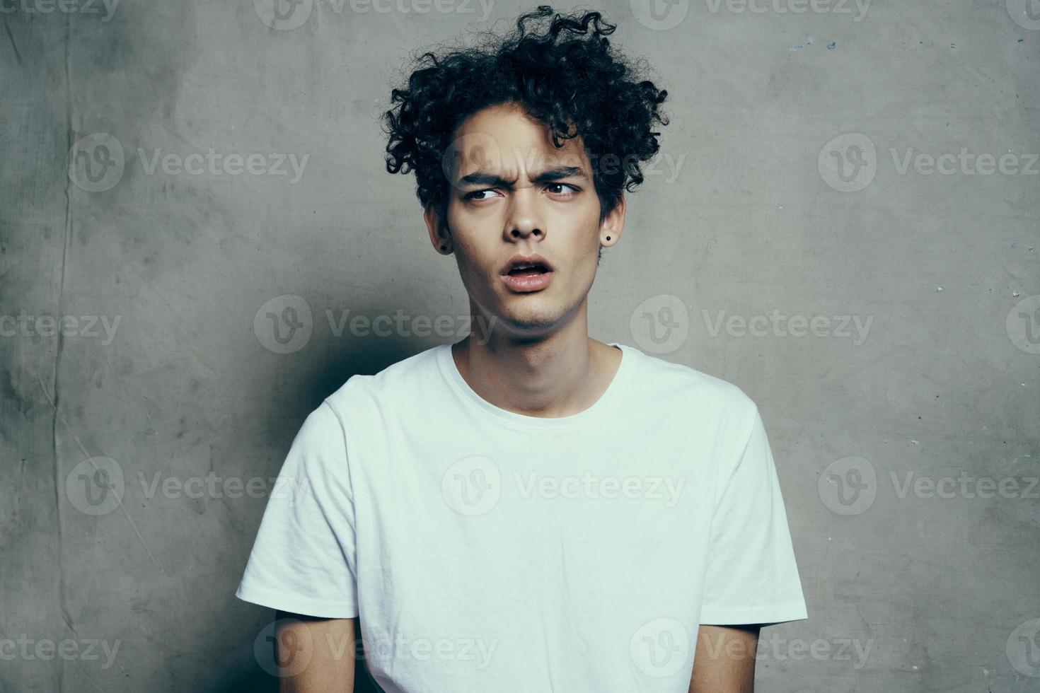 handsome man curly hair white t-shirt emotions studio photo