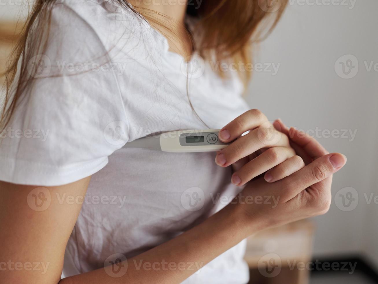 woman t-shirt thermometer in hands checking temperature health photo